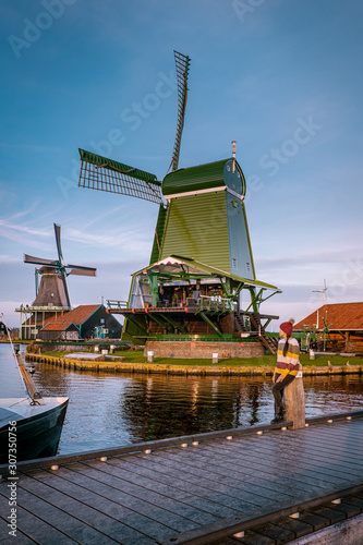 woman walking at the old windmill village Zaanse Schans Netherlands, historical windmill village near Amsterdam photo