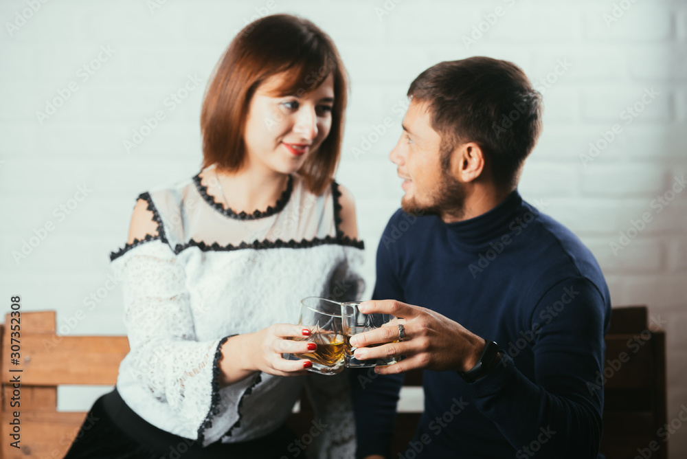 Young couple guy and girl drink whiskey on a date Young couple guy and girl drink whiskey on a date