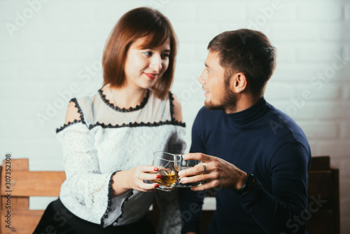 Young couple guy and girl drink whiskey on a date