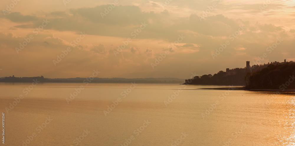 Sunset over Lake Trasimeno in Umbria, with islands, old ruins and evening mist