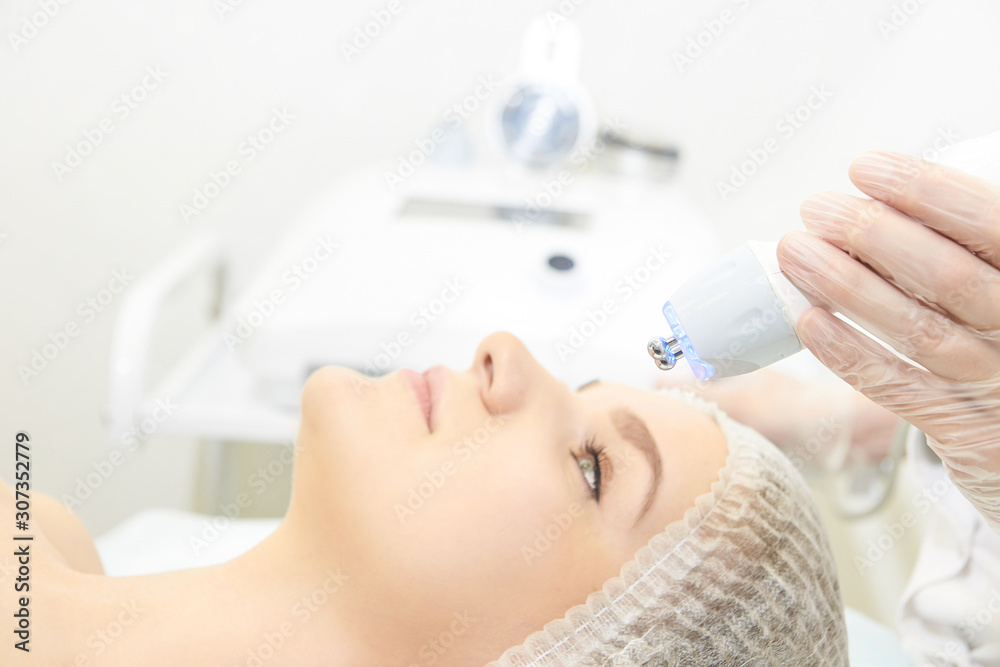 Naklejka premium Dermatology skin care facial therapy. Medical spa anto wrinkles procedure. Woman face rejuvenation. Pretty girl. Rf cosmetician equipment