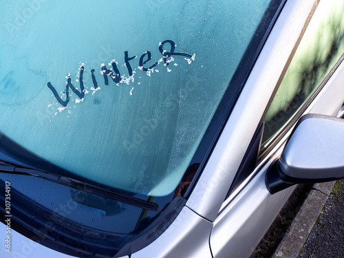 Winter written in the ice on a car windscreen on a cold frosty morning