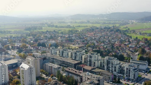 Aerial tilt up shot revealing the city of Domzale, Slovenia, with green fields and hills in the distance photo