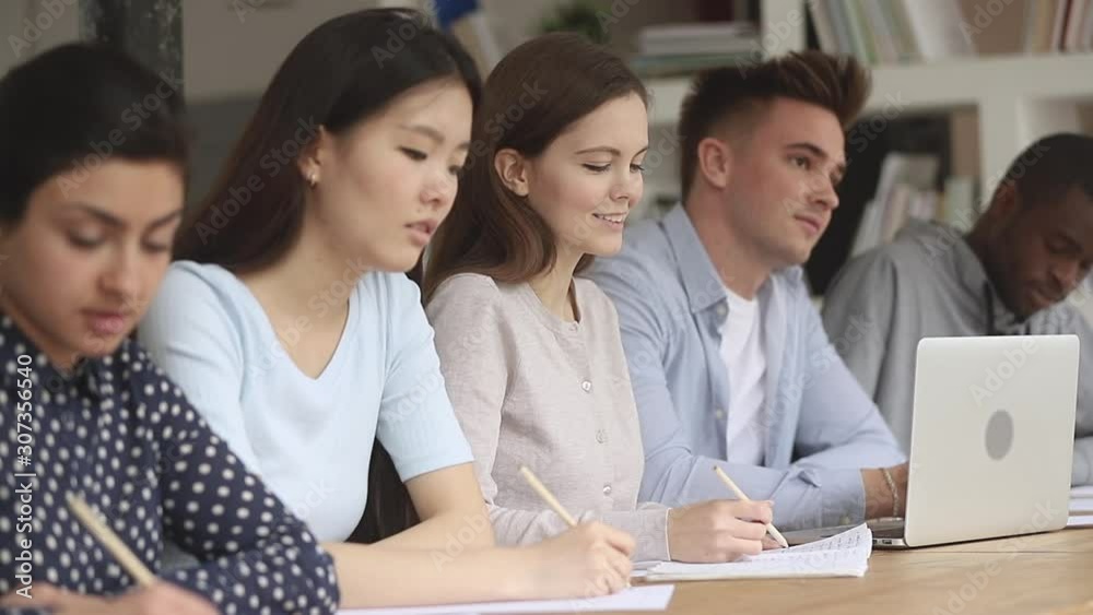 Mixed race groupmates sitting on educational lecture. Mixed race groupmates sitting on educational lecture.