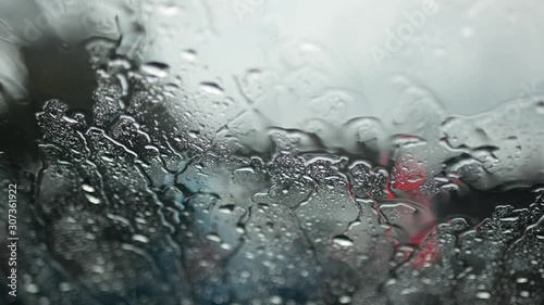 Selective focus background of rain falling on a car windshield while being stuck in a traffic jam
