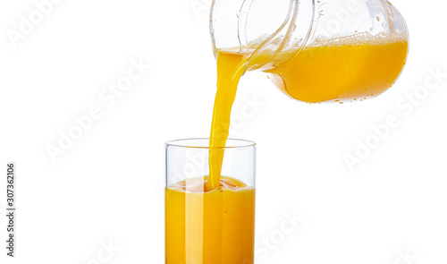 Canvastavla Orange juice pouring from pitcher into glass isolated on white background