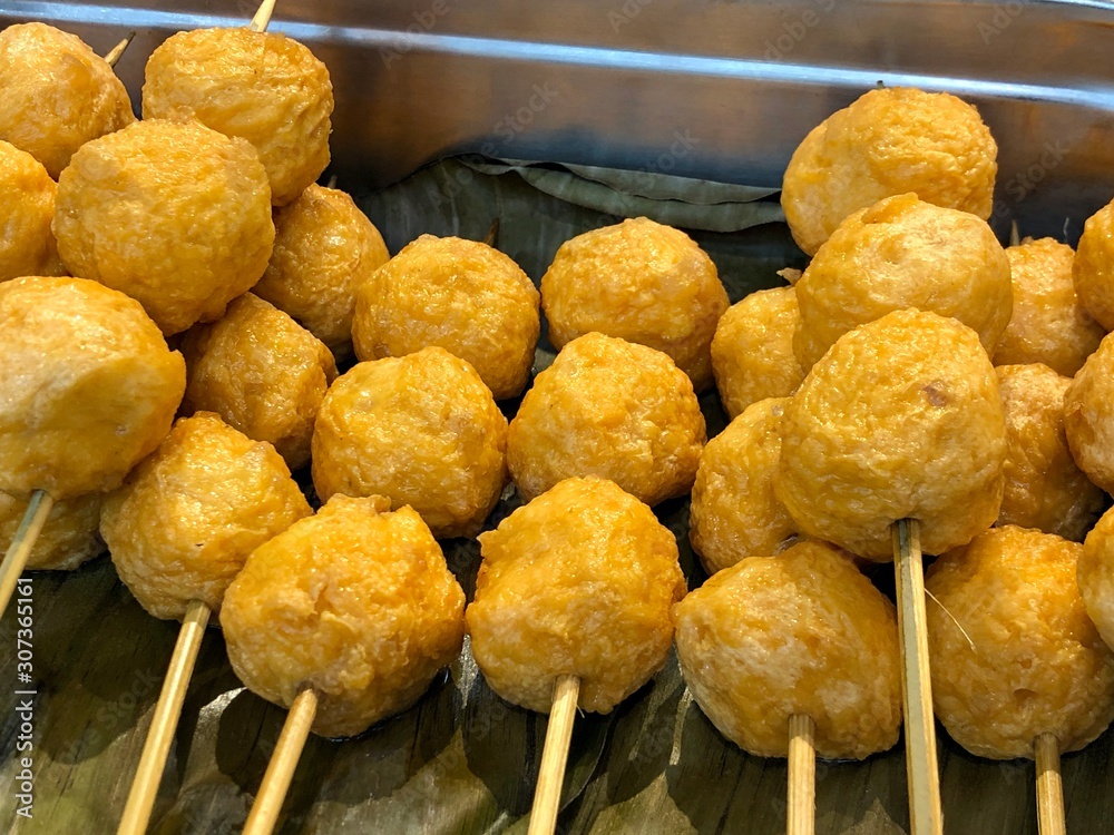 Fish balls on sticks placed on a banana leaf. Fishballs are popular  streetfoods in the Philippines Stock Photo
