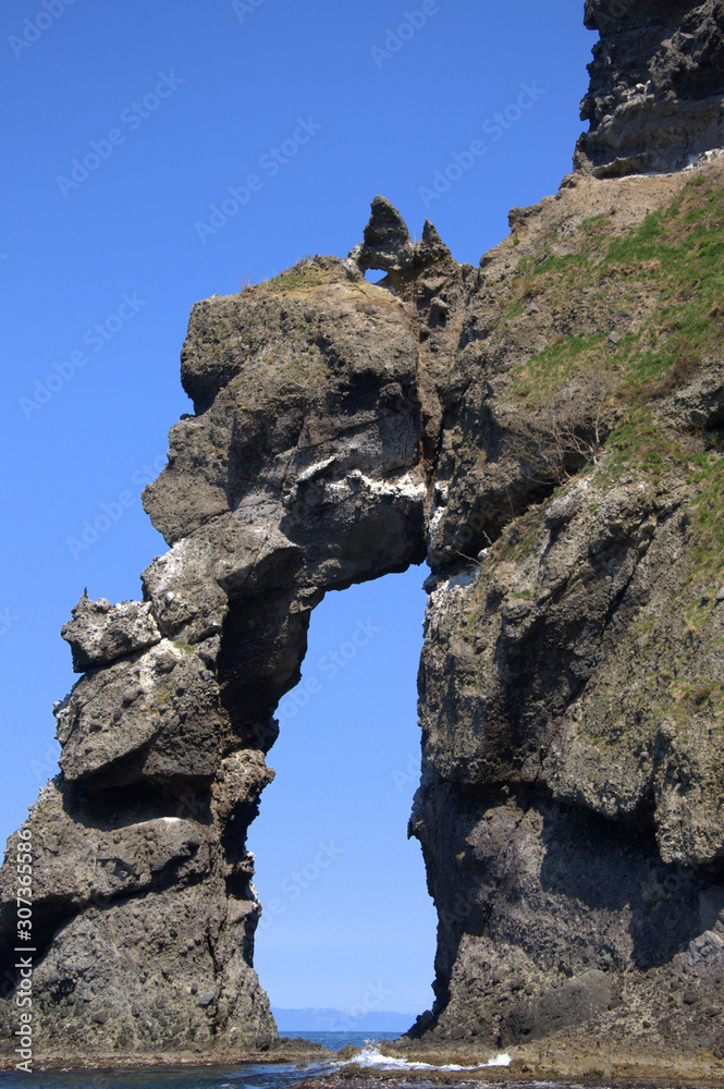 craggy natural stone archway looking out to the sea on a clear sunny day craggy natural stone archway looking out to the sea on a clear sunny day