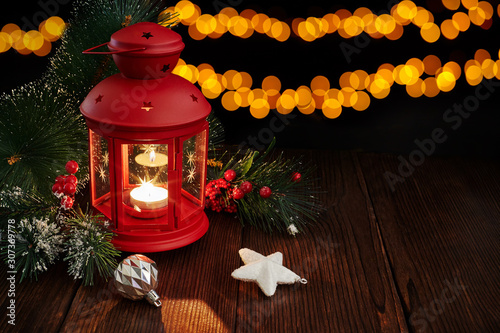 Christmas lantern with decorations and snow on bokeh background.