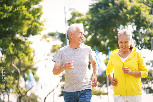 senior asian couple running in park photo