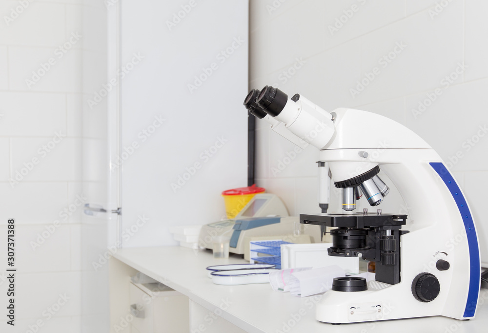 Close up of modern microscope on table with samples Close up of modern microscope on table with samples