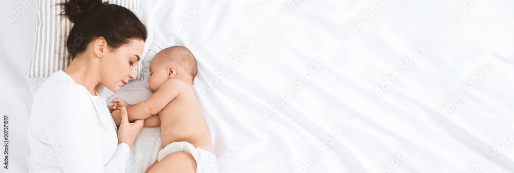 Young mom sleeping with her baby, panorama with empty space - obrazy, fototapety, plakaty 