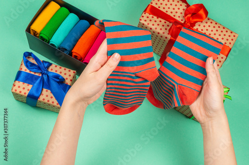 Colorful collection of cotton socks as a gift in woman hands. © Nikolay