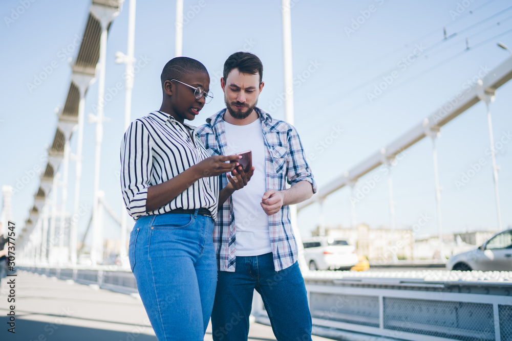 African American lady browsing phone chilling with friend in street African American lady browsing phone chilling with friend in street