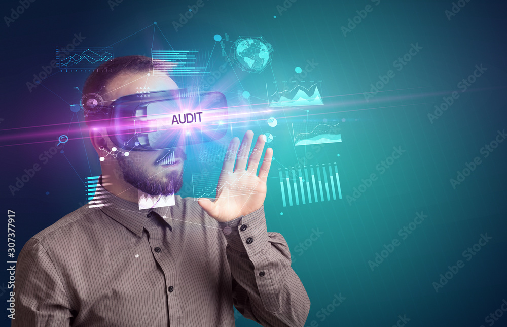 Businessman looking through Virtual Reality glasses with AUDIT inscription, new business concept Businessman looking through Virtual Reality glasses with AUDIT inscription, new business concept