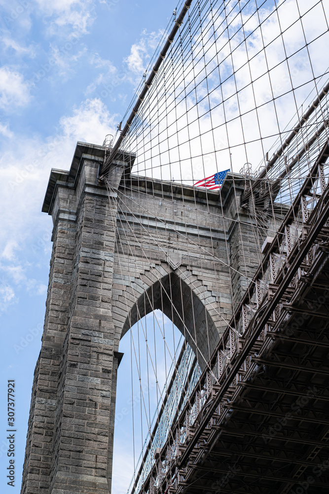 Fototapeta premium Puente de Brooklyn junto a la bandera de los Estados Unidos