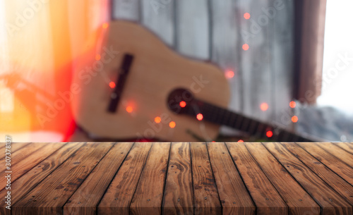 Empty wooden table with blurred musical background. banner for advertising guitar,