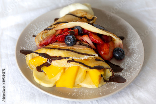 Crepes with Fresh Berries, Chocolate Sauce and Powdered sugar photo