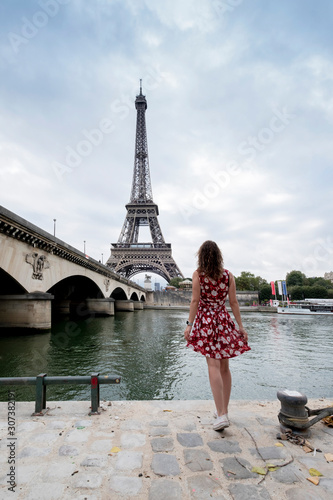 Woman in a floral dress and the Eiffel Tower in Paris in the background © ikuday