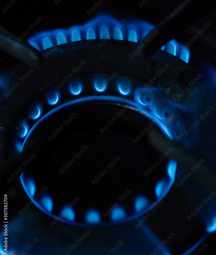 A Macro Image of a Blurry Blue Flames on Gas Stove Burner. A Macro Image of a Blurry Blue Flames on Gas Stove Burner.