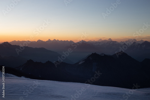 beautiful sunrise in the mountains. Golden hour photography, the rising sun behind the mountains. Yellow and pink color. Mount Elbrus. Russia. The Caucasus. Panorama of mountains at sunrise.