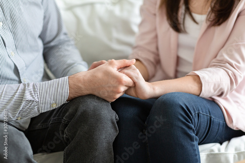Married couple holding each other hands during family therapy photo