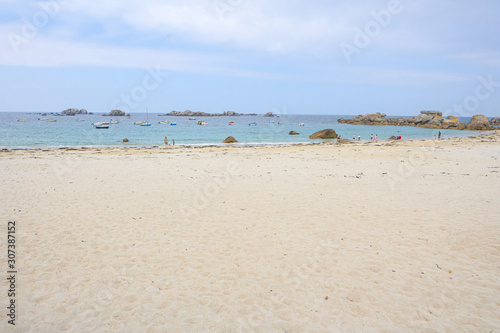 Beach with white sand, a few people and small boats in the water © stock mp