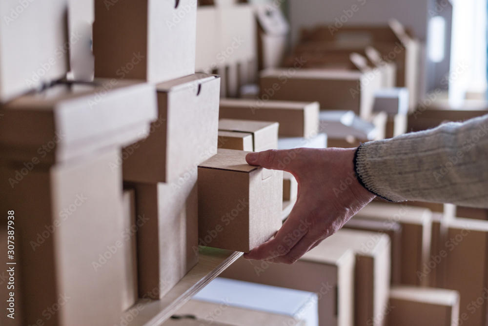 Lot of different cardboard carton boxes in the warehouse. Man hand take the box