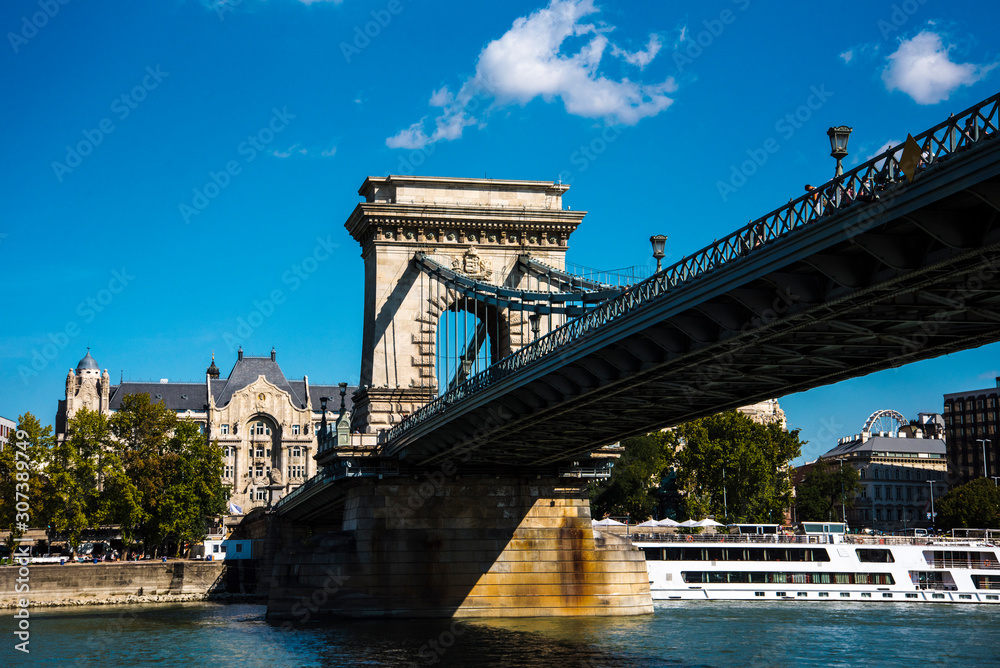 Obraz premium Budapest the Capital city of Hungary is divided by the River Danube.The Chain Bridge opened in 1849 was designed by UK engineer William Tierney Clark