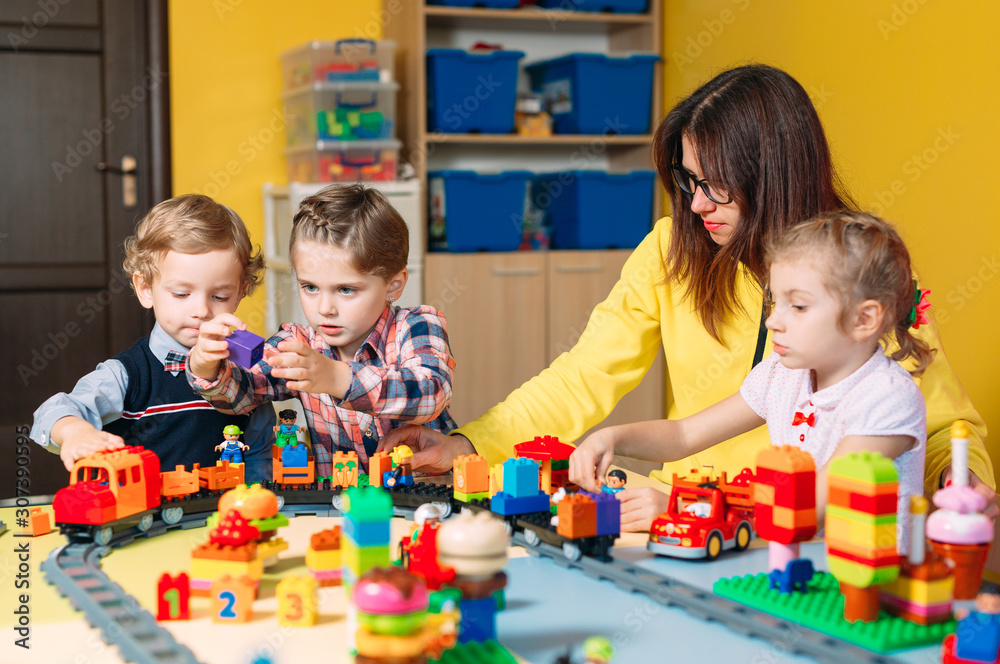 Naklejka premium Educational toys for preschool and kindergarten child. Child playing with constructor blocks at class.
