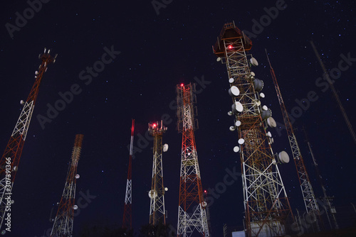 From below, a high, modern radio tower located in a starry sky in one night.