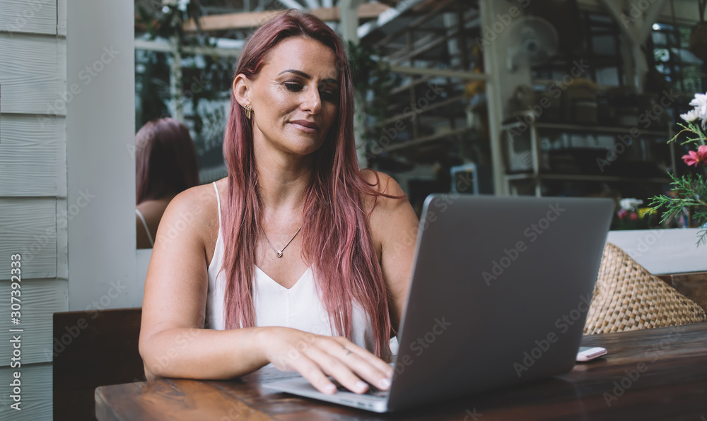 Adult freelancer using laptop in cafe Adult freelancer using laptop in cafe