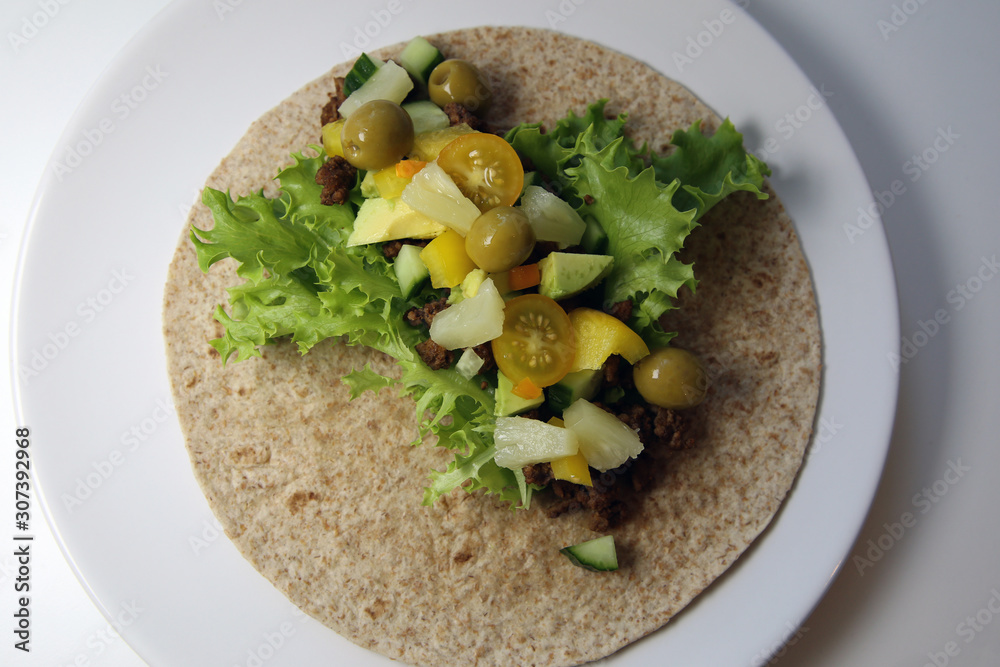 Healthy &delicious homemade tortilla including whole wheat tortilla shell, fresh salad, minced taco meat, tomatoes, pepper, avocado, cucumber, olives & pineapple. Nutritious version of Mexican classic Healthy &delicious homemade tortilla including whole wheat tortilla shell, fresh salad, minced taco meat, tomatoes, pepper, avocado, cucumber, olives & pineapple. Nutritious version of Mexican classic