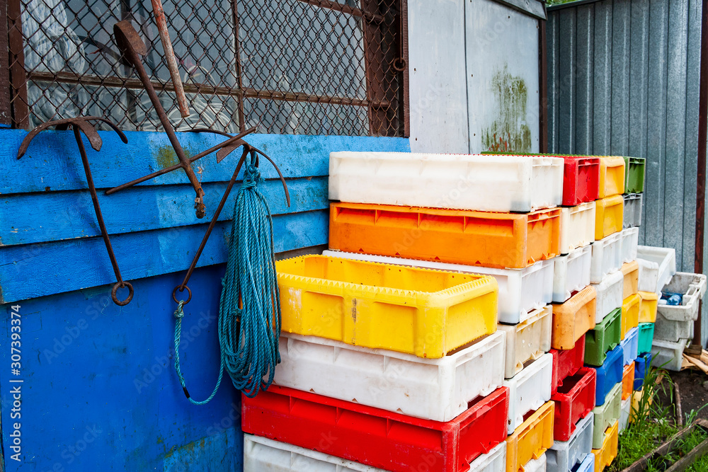 Anchors and colorful plastic fish crates in harbor Stock Photo