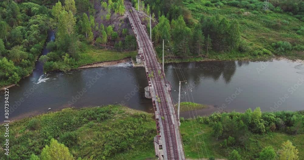 Old destroy rusty narrow gauge railways on bridge in wild abandoned forest landscapes / summer sunset - Aerial drone top down view
