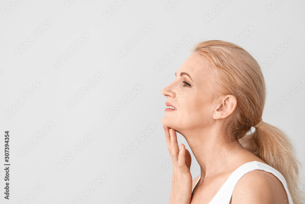 Portrait of beautiful mature woman on light background Portrait of beautiful mature woman on light background