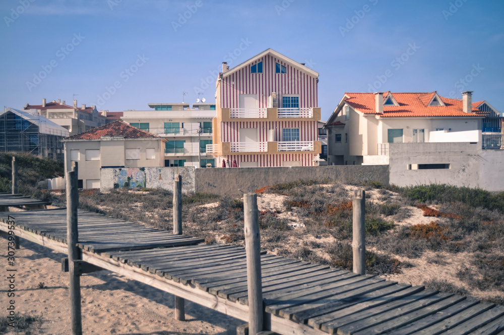 The path of the boards, colored houses on the background. Colorful Aveiro. Portugal. Summer time