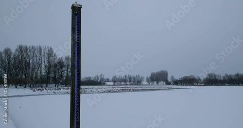 Normaal Amsterdams Peil (NAP), Amsterdam Ordinance Level, a vertical level meter in flooded river landscape + pan winter scenery photo