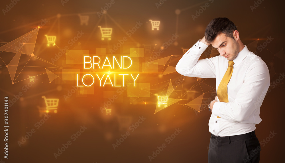 Businessman with shopping cart icons and BRAND LOYALTY inscription, online shopping concept Businessman with shopping cart icons and BRAND LOYALTY inscription, online shopping concept