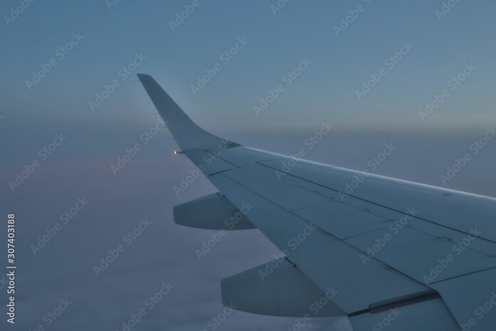 wing of an airplane flying above clouds wing of an airplane flying above clouds
