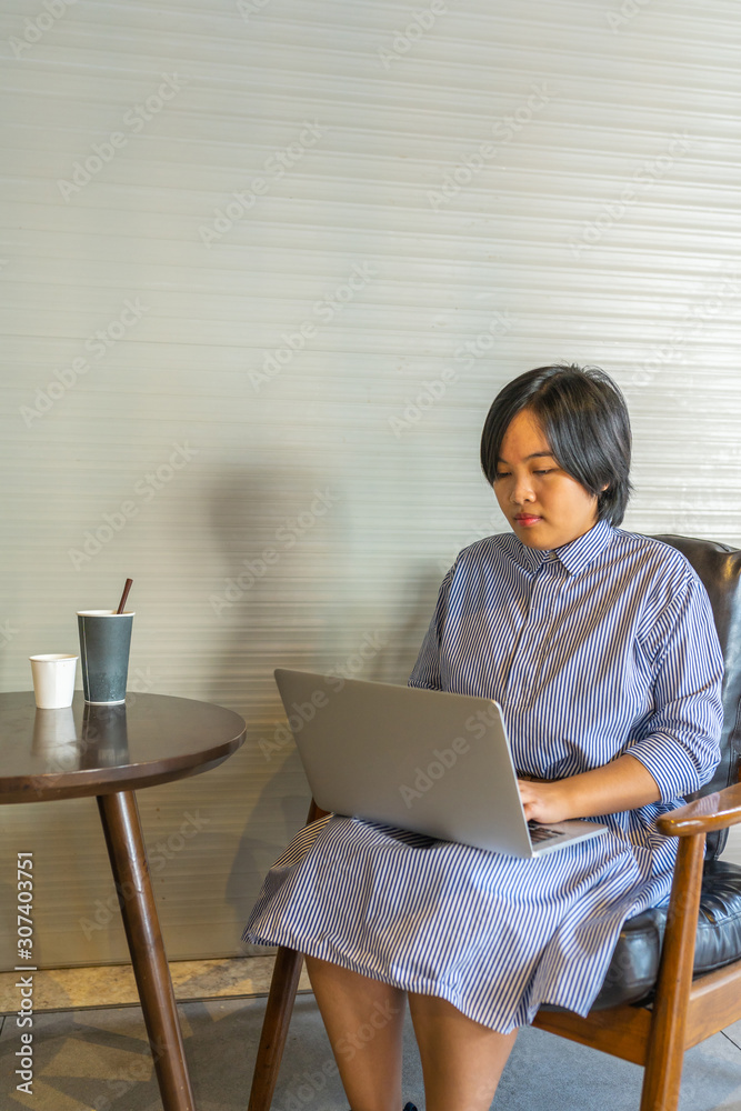 Asian female freelance copywriter working on laptop at coffeeshop Asian female freelance copywriter working on laptop at coffeeshop
