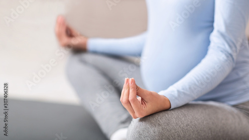 Closeup of young expectant meditating on the floor