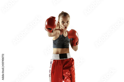 Young female kickboxing fighter training isolated on white background. Caucasian blonde girl in red sportswear practicing in martial arts. Concept of sport, healthy lifestyle, motion, action, youth.