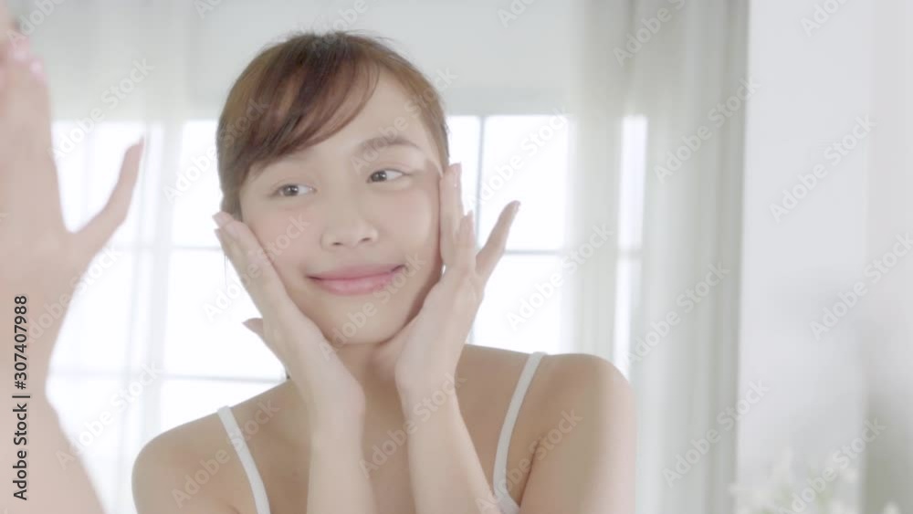 beautiful young asian woman happy applying cream or lotion with moisturizer to skin face, beauty asia girl applying skincare touch facial with cosmetic makeup, healthy and wellness concept. beautiful young asian woman happy applying cream or lotion with moisturizer to skin face, beauty asia girl applying skincare touch facial with cosmetic makeup, healthy and wellness concept.
