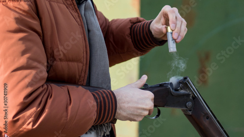 gun in the hands of a man and smoke from a shot