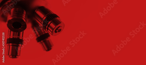 Optical microscope - science and laboratory equipment. Microscope is used for conducting planned, research experiments, educational demonstrations in medical and clinical laboratories. Red tone.
