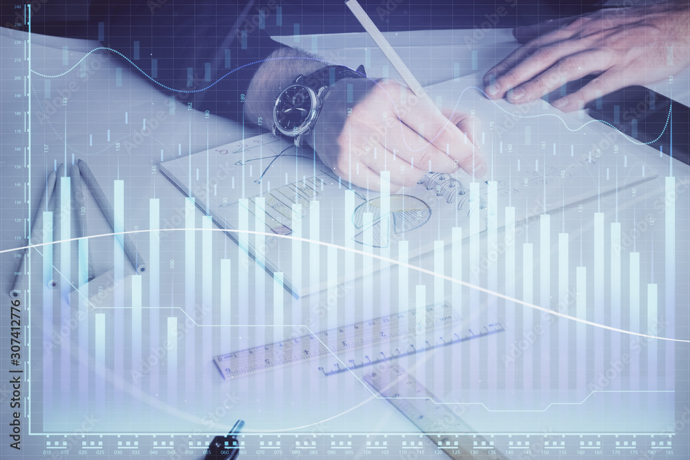 Double exposure of man's hands writing notes of stock market with forex chart. Double exposure of man's hands writing notes of stock market with forex chart.