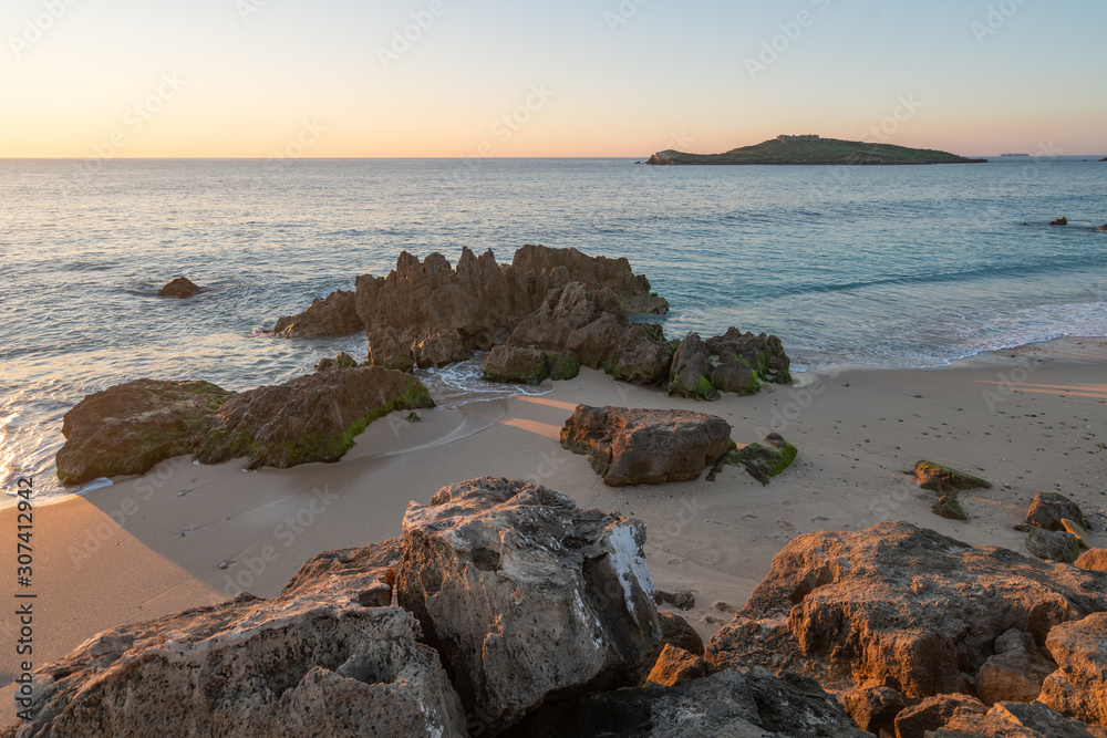 Porto Covo beach at sunset with Ilha do Pessegueiro Island on the background, in Portugal