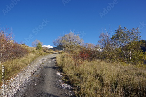 Sentier piste de randonnée et montagne enneigée au fond