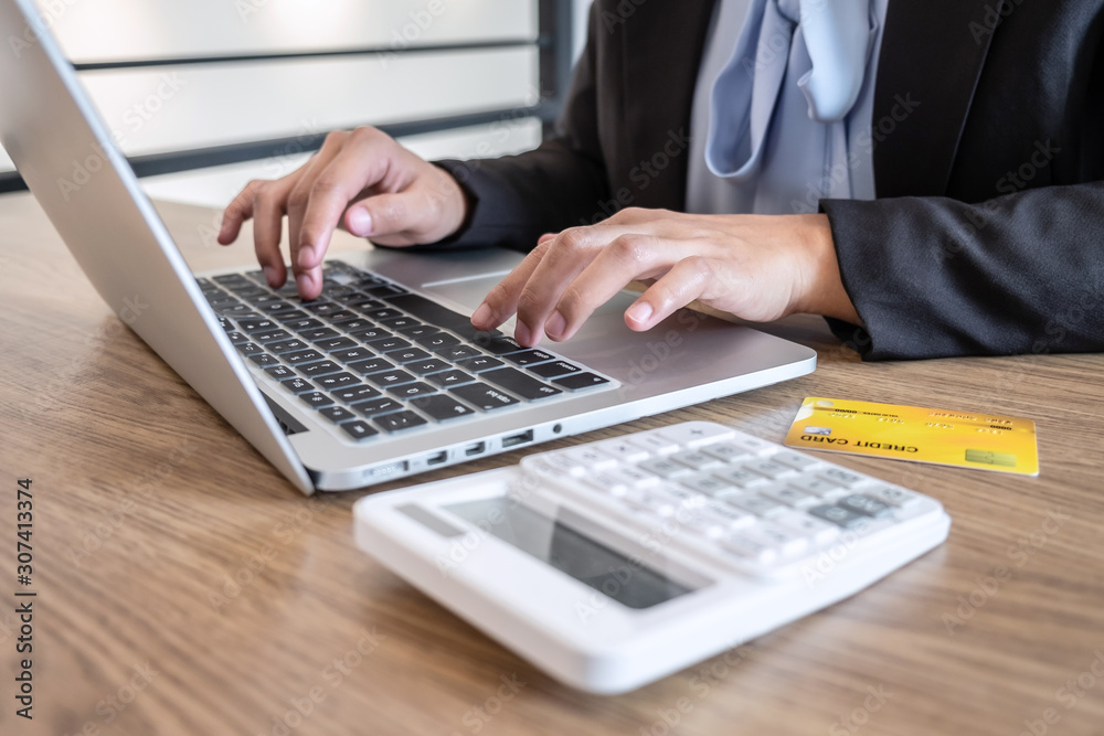 Businesswoman using laptop and holding credit card for paying detail page display online shopping purchase and entry security code to inputting card information Businesswoman using laptop and holding credit card for paying detail page display online shopping purchase and entry security code to inputting card information